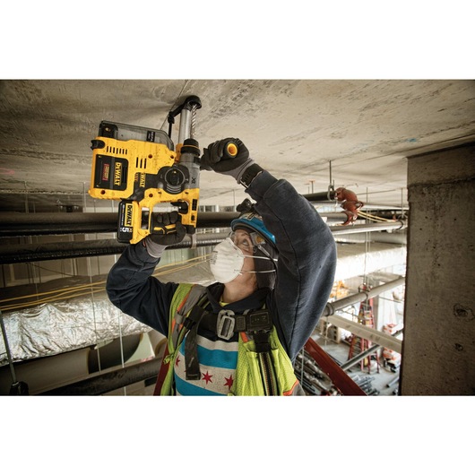 Brushless, cordless SDS PLUS L-shape rotary hammer being used by a person